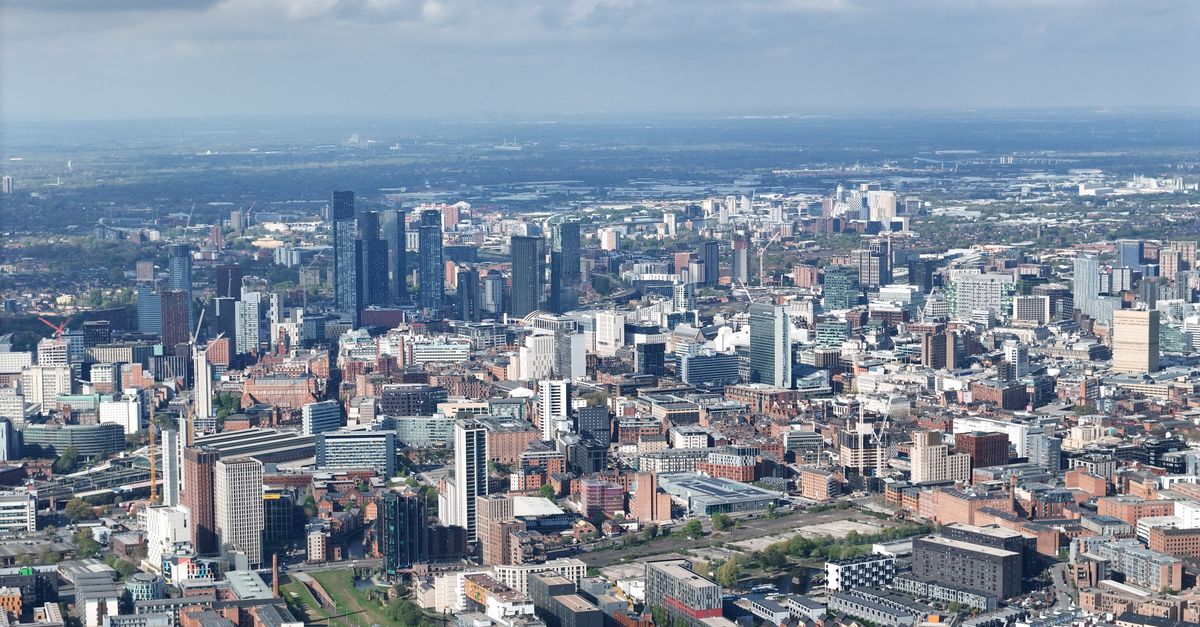 Stunning aerial photograph of Manchester's urban skyline showcasing modern architecture under scattered clouds.